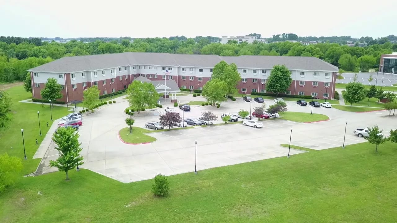 Aerial view of a senior living facility with parking and gardens
