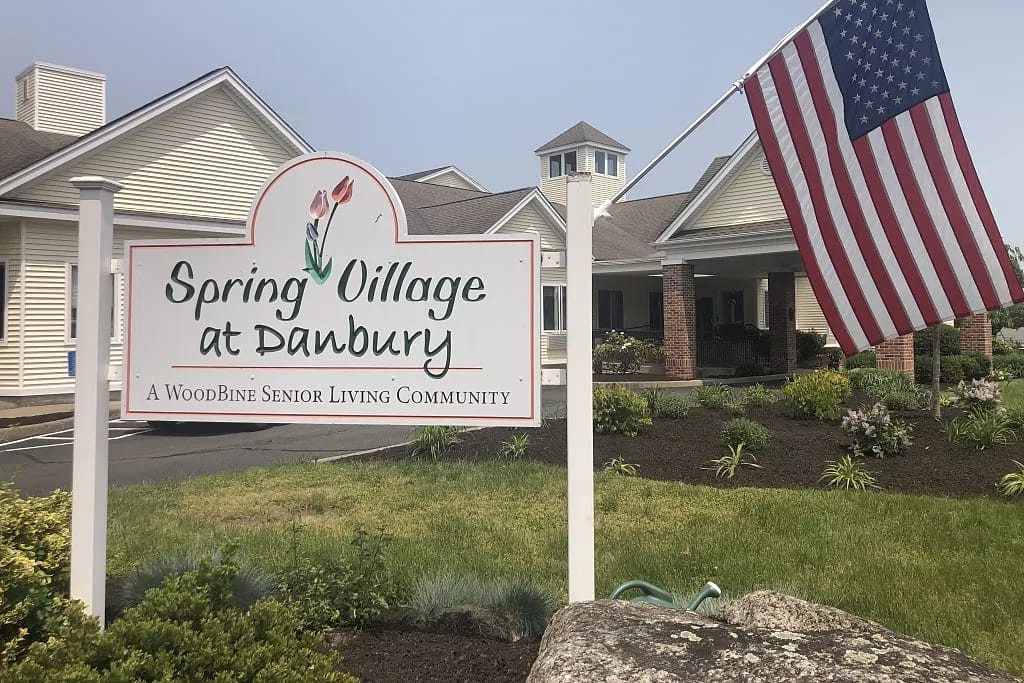 Exterior view of Spring Village at Danbury with sign and flag