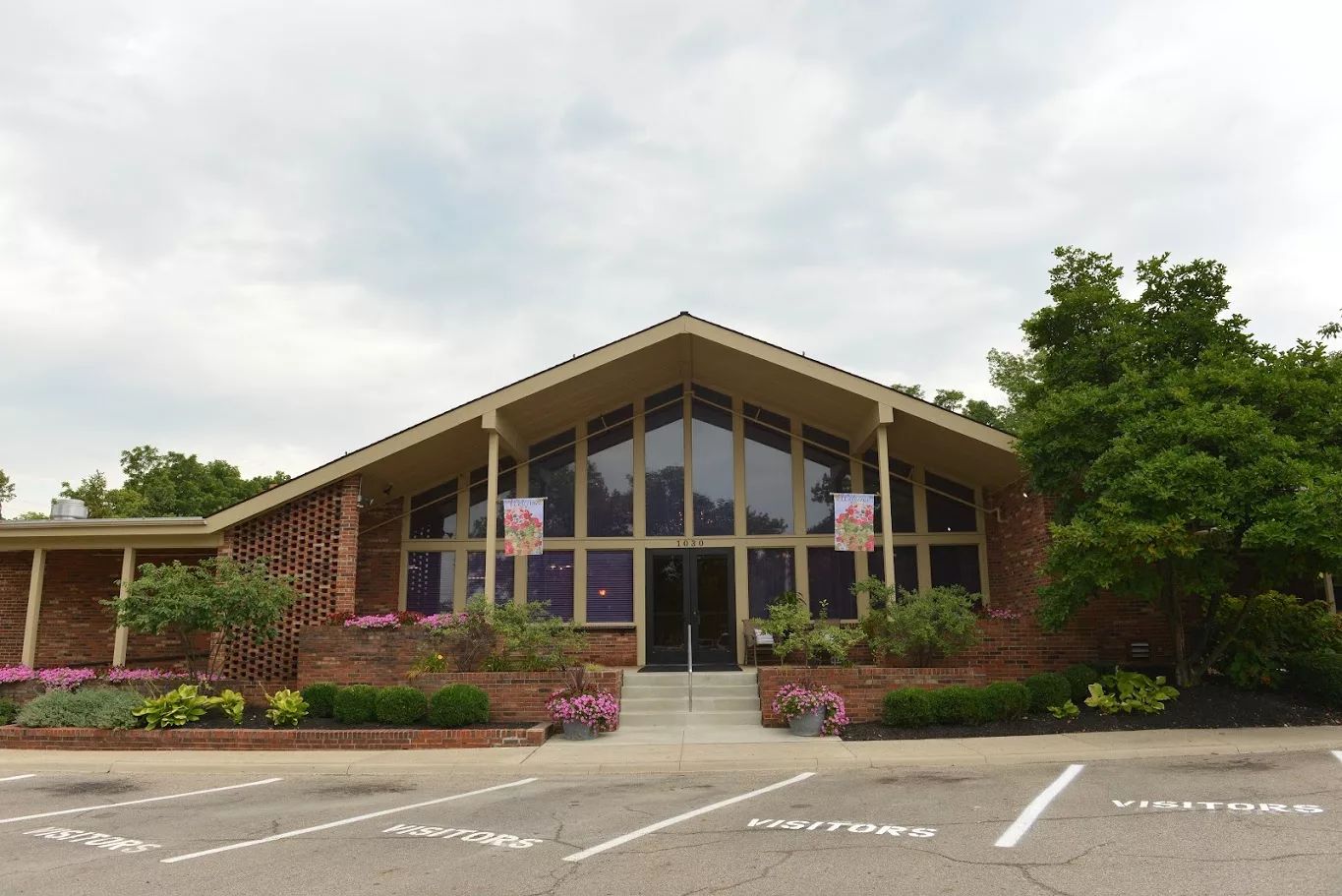 Front view of a senior living facility with a landscaped entrance