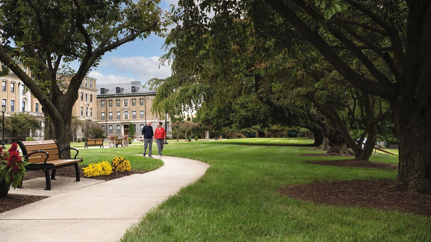 Residents walking on a path surrounded by trees