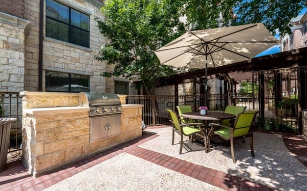 Outdoor seating area with grill and umbrella