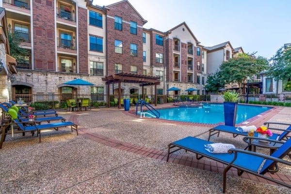Outdoor pool area with lounge chairs and umbrellas