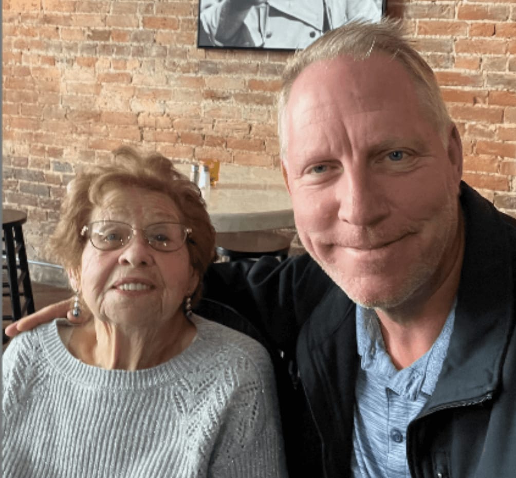 A resident and staff member smiling together