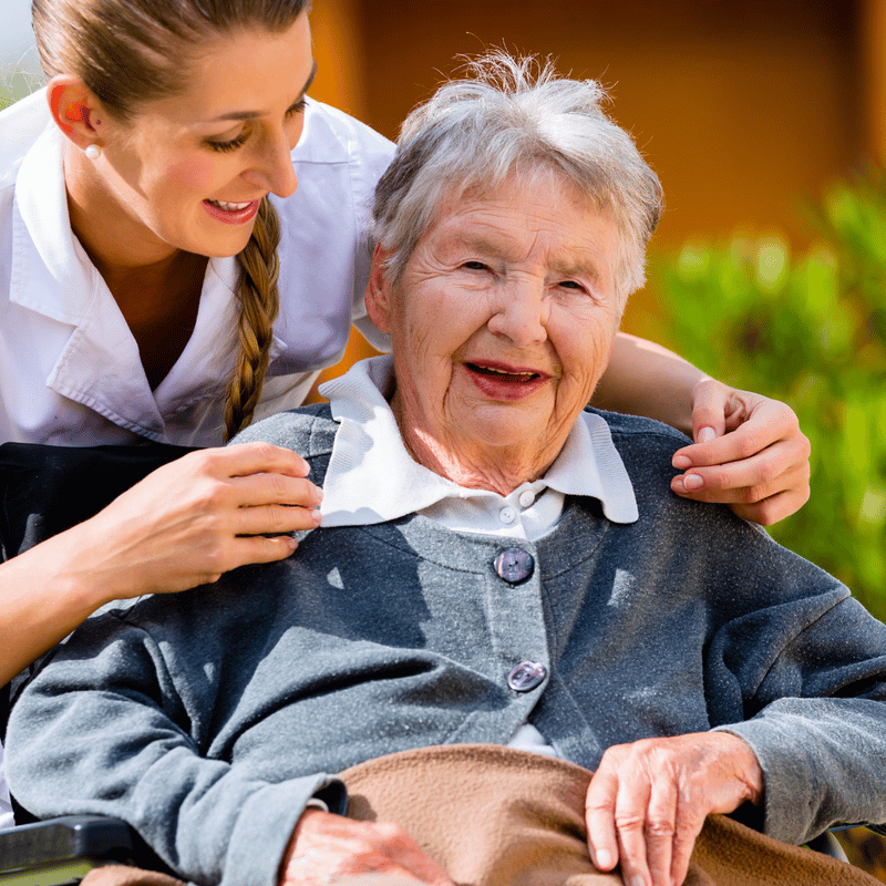 Salus Home Care, home care in San Diego, CA — Caregiver assisting a smiling elderly woman in a wheelchair