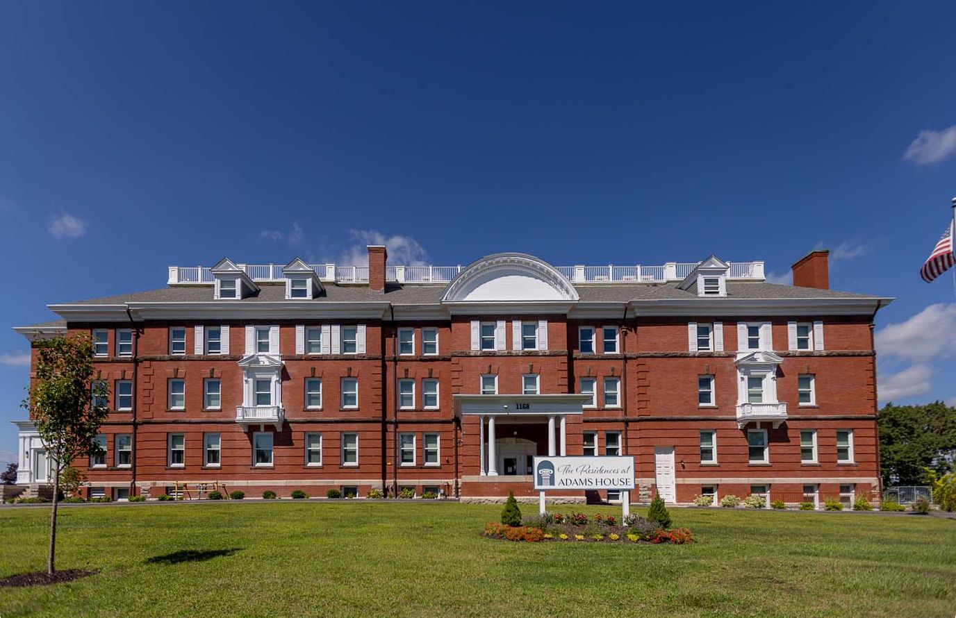 Exterior view of Adams House facility with blue sky