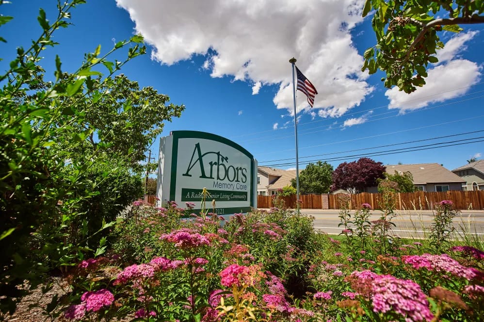 Facility sign for Arbors Memory Care with flowers
