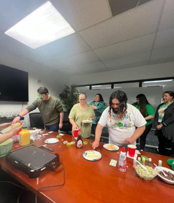 Staff and residents preparing food together in an activity room