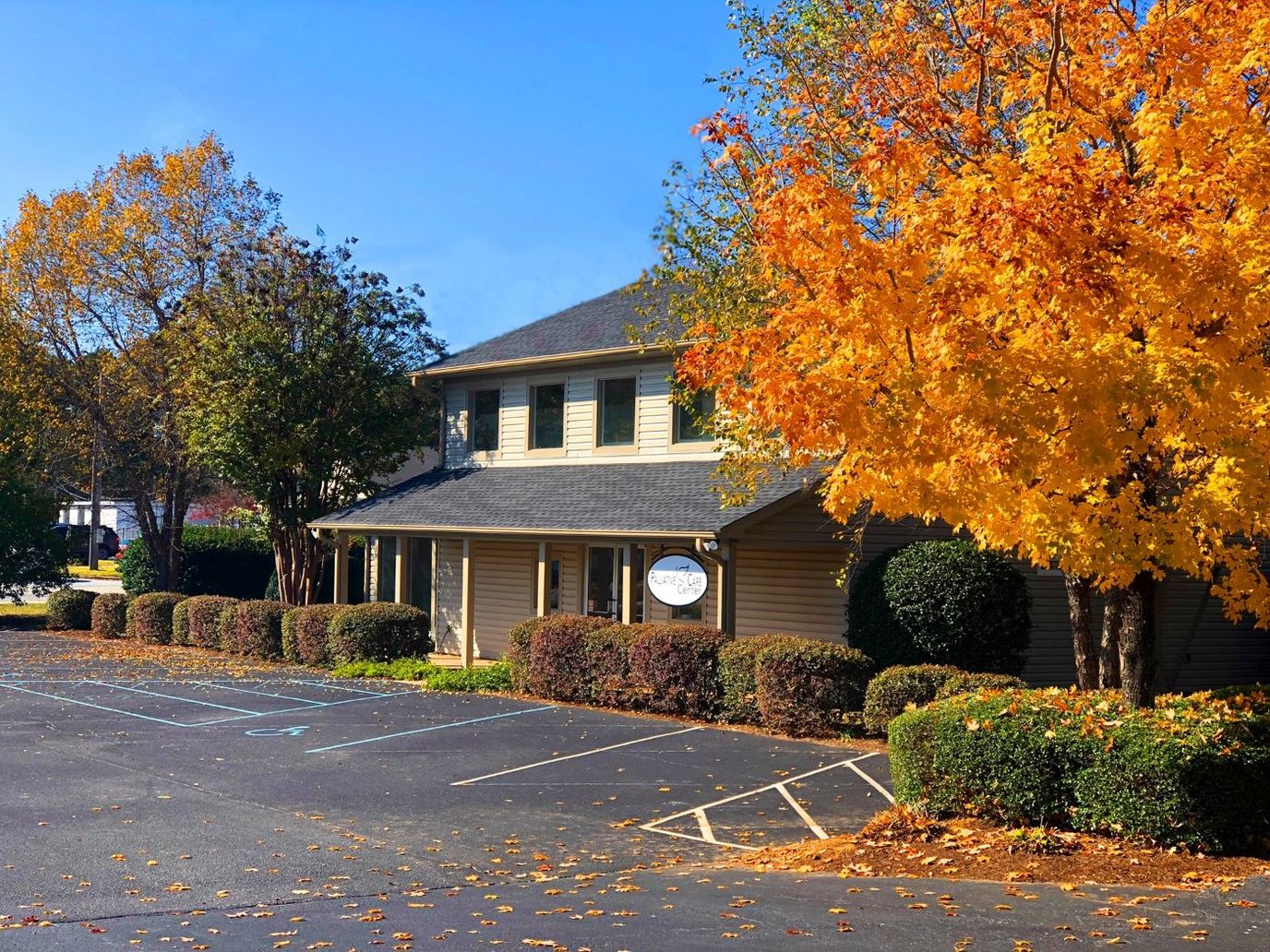 Exterior view of a senior care facility surrounded by autumn trees