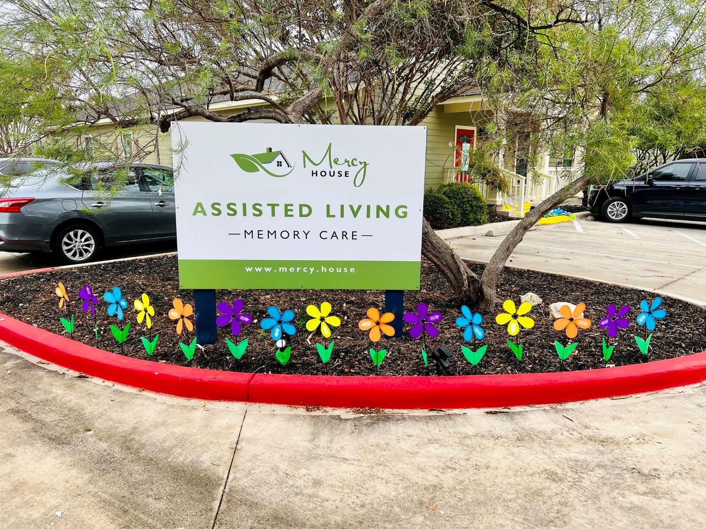 Signage for Mercy House Assisted Living with flowers