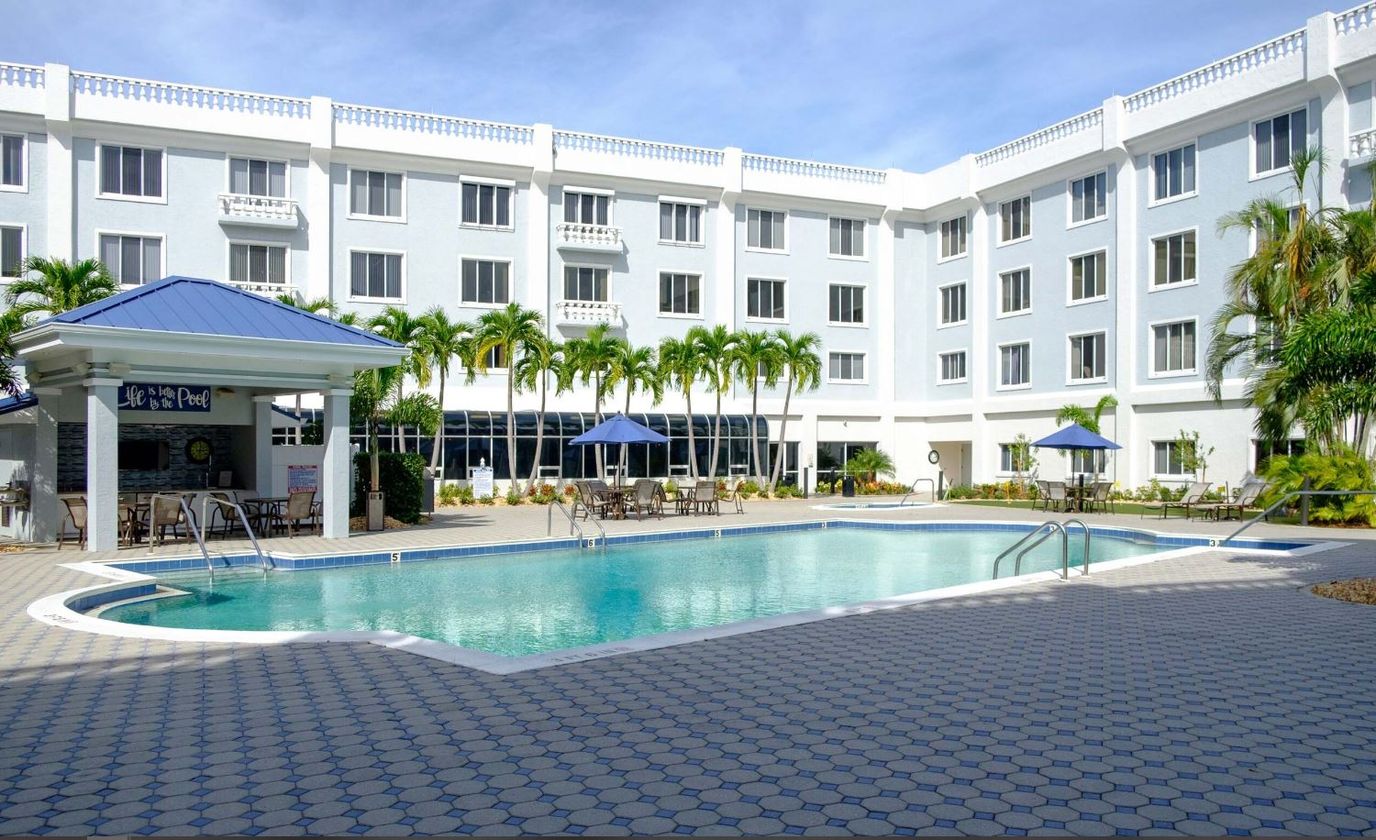 Outdoor pool area with palm trees and building facade