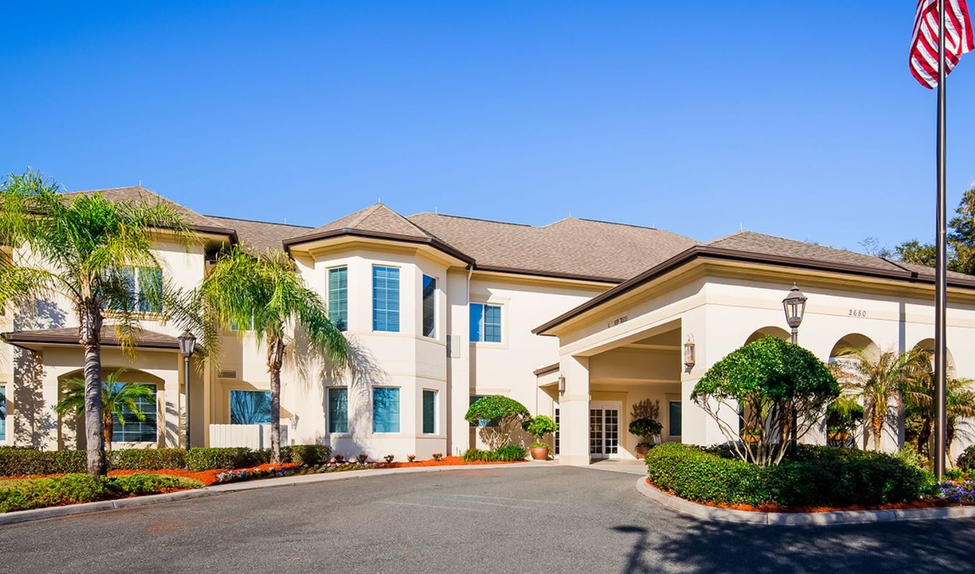 Exterior view of The Windsor at Ocala with landscaped entrance
