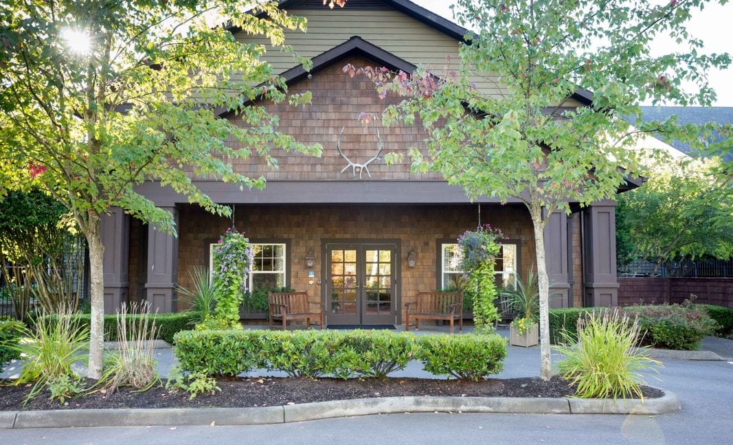 Exterior view of a senior living facility with gardens