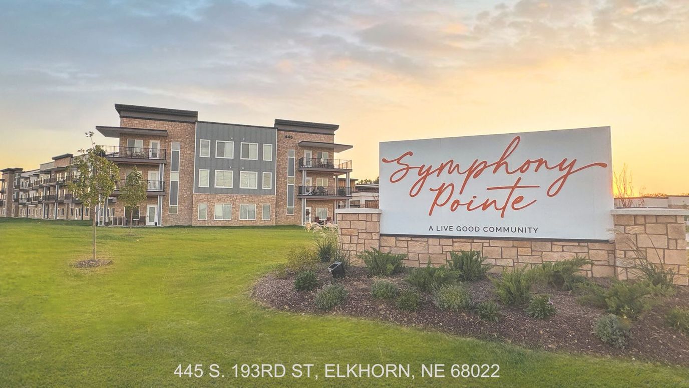 Building exterior of Symphony Pointe with community sign