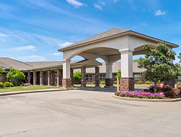 Exterior view of Heritage Manor entrance with landscaped flowers