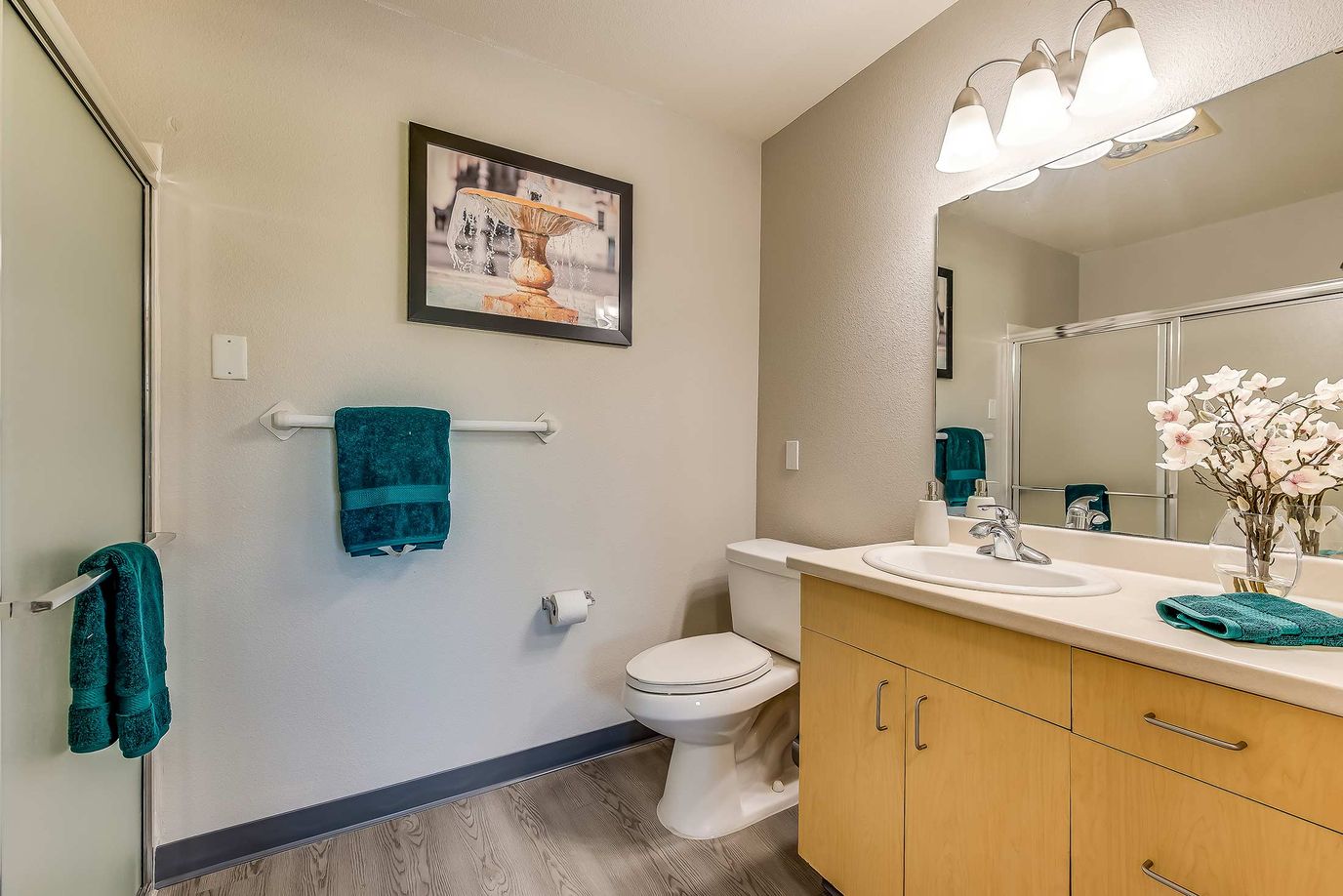 Bright bathroom with floral decoration and teal accents