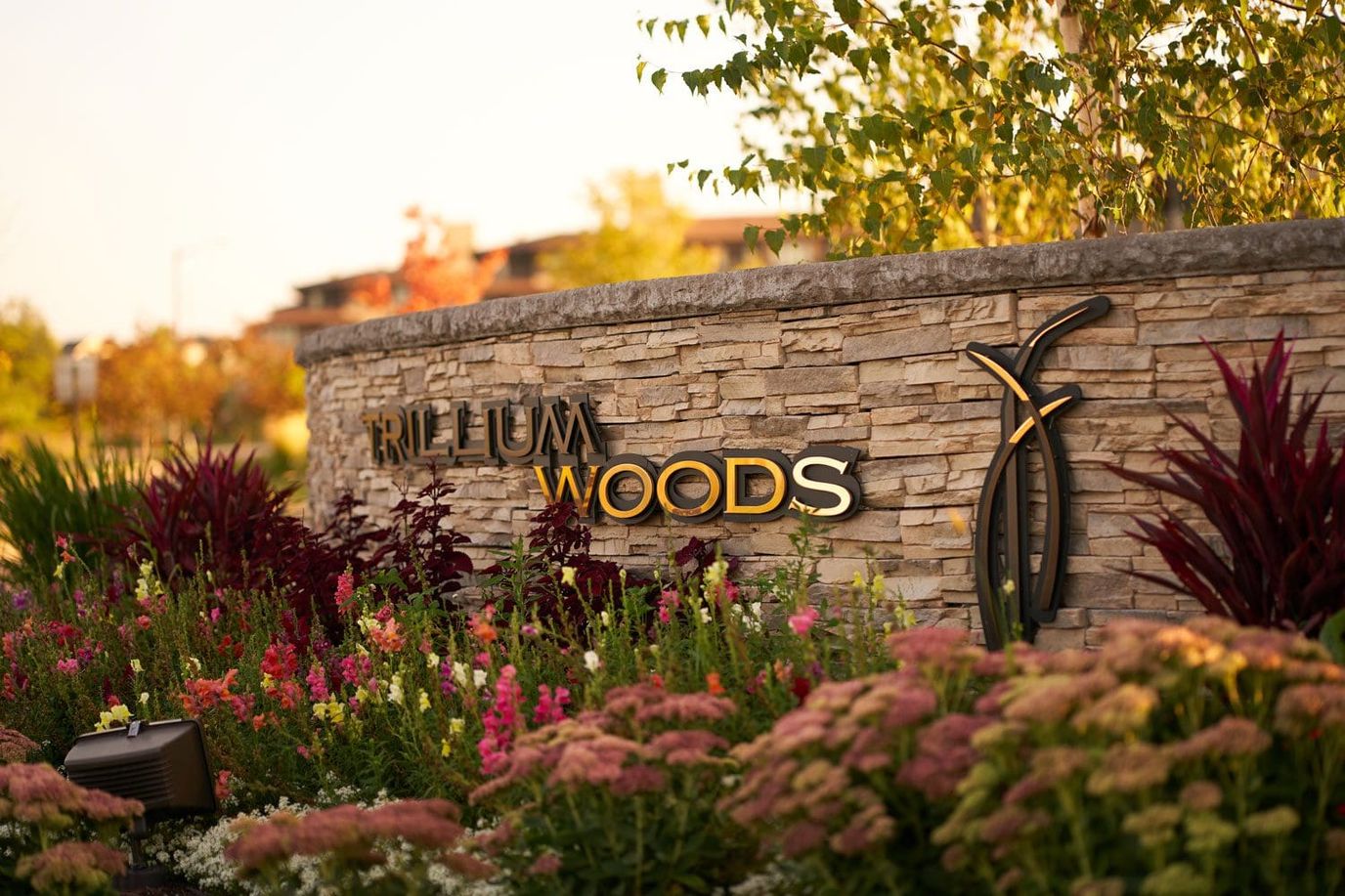 Facility logo displayed on a stone wall with flowers