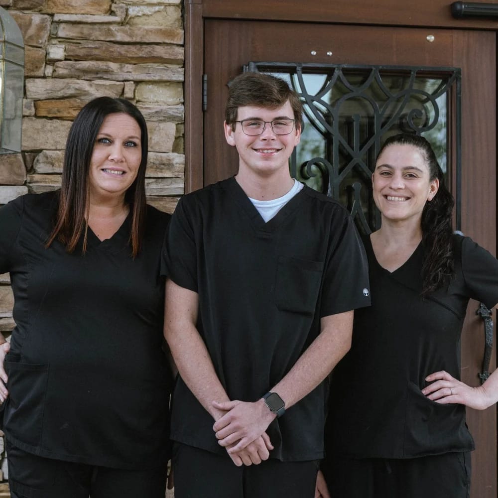 Staff members posing outside the facility entrance