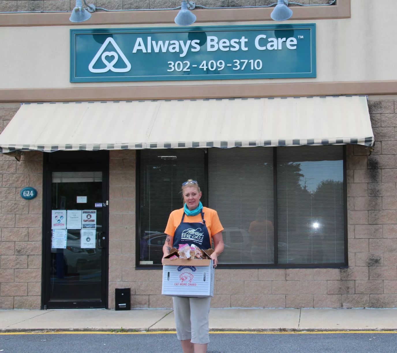 Person holding a box outside a senior care facility