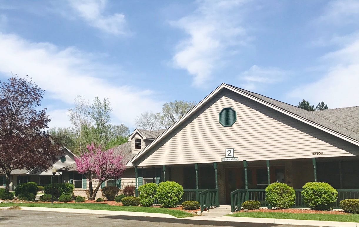 Exterior view of Aspen Assisted Living facility with landscaping