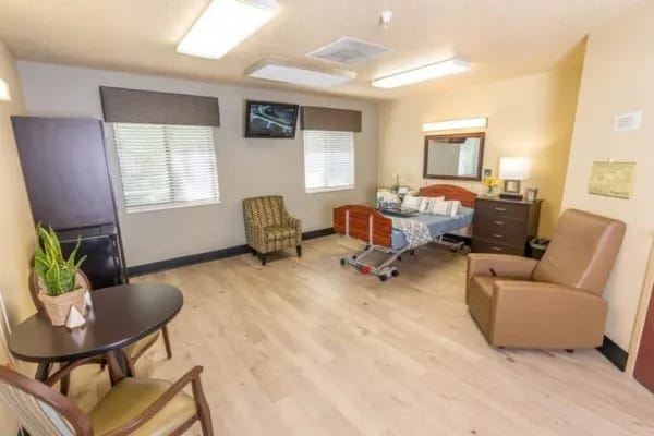 Bright private resident room with furniture and TV
