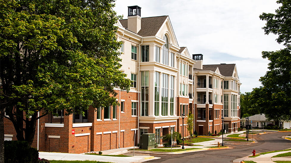 Exterior view of a senior living facility with landscaped walkway