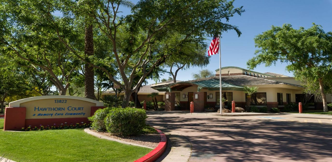 Exterior view of Hawthorn Court with landscaping and flag