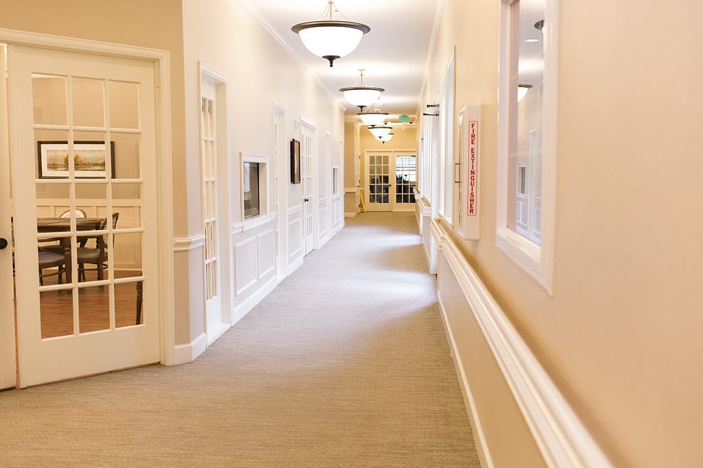 Well-lit hallway in the Heritage at Eldridge Parkway senior living facility.