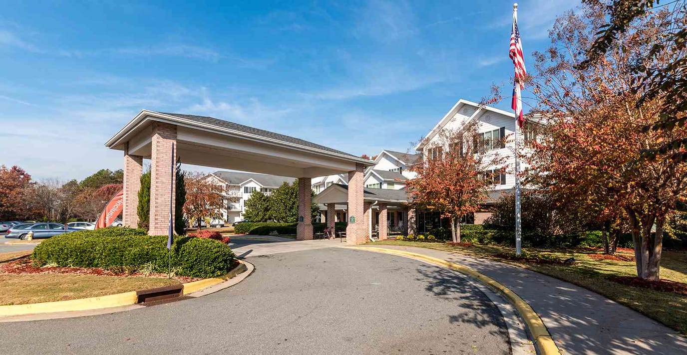 Entrance of a senior living facility with landscaped surroundings