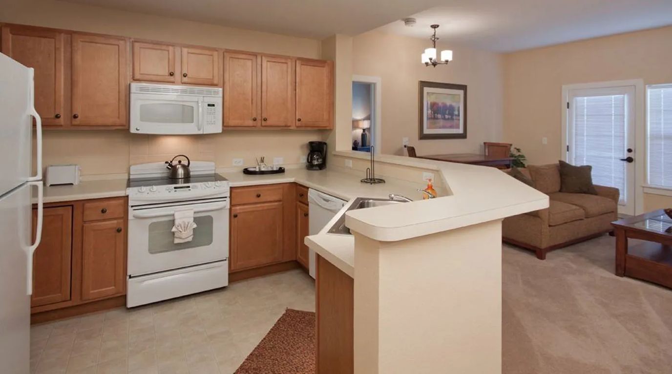Modern kitchen with appliances and seating area.