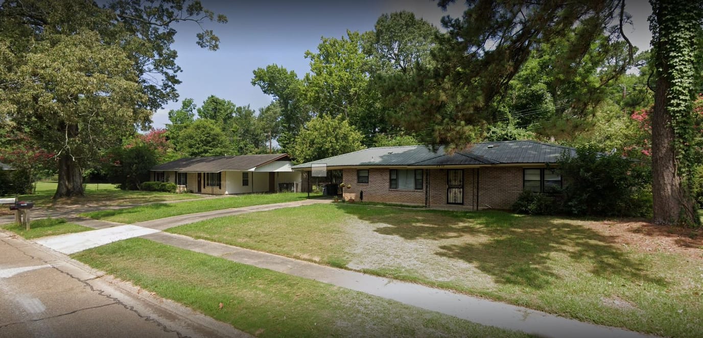 Exterior view of assisted living facility with green surroundings