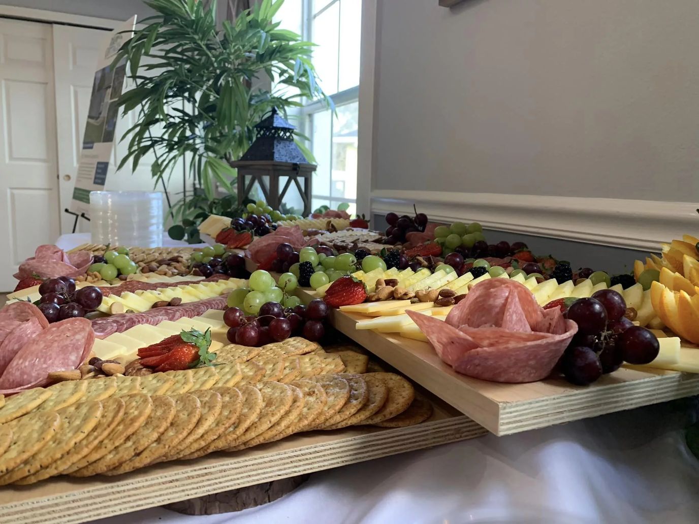 A variety of cheeses, meats, and fruits arranged on a table.
