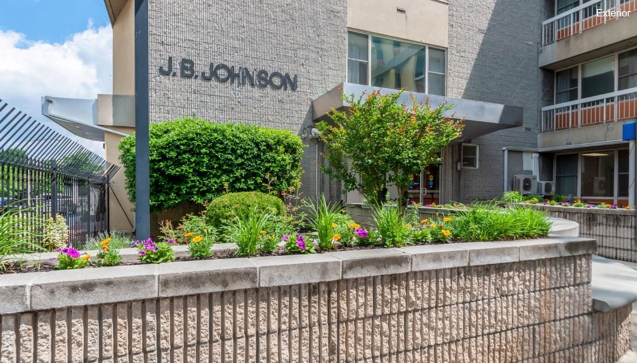 Exterior view of J. B. Johnson's entrance with floral landscaping