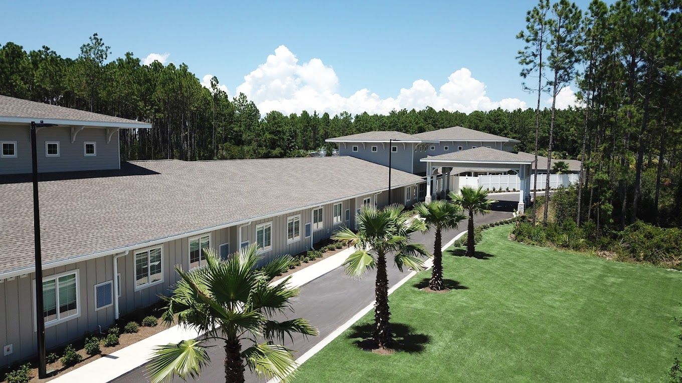 Exterior view of the assisted living facility surrounded by greenery