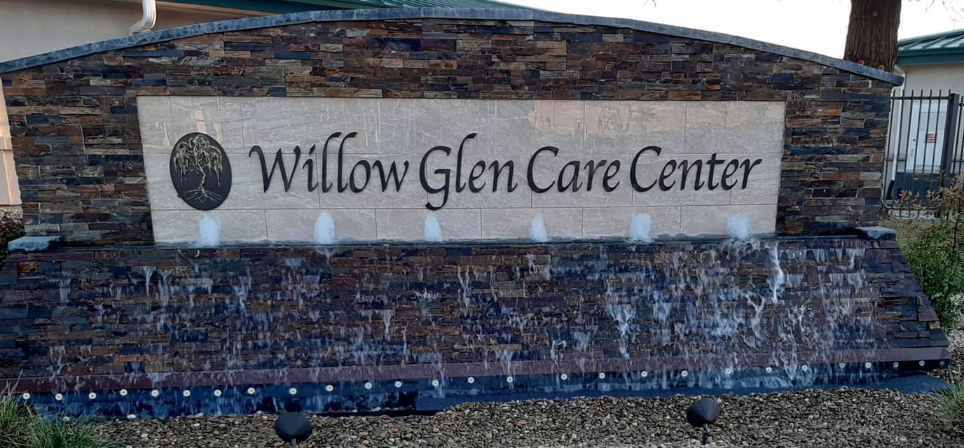 Exterior sign of Willow Glen Care Center with a water feature