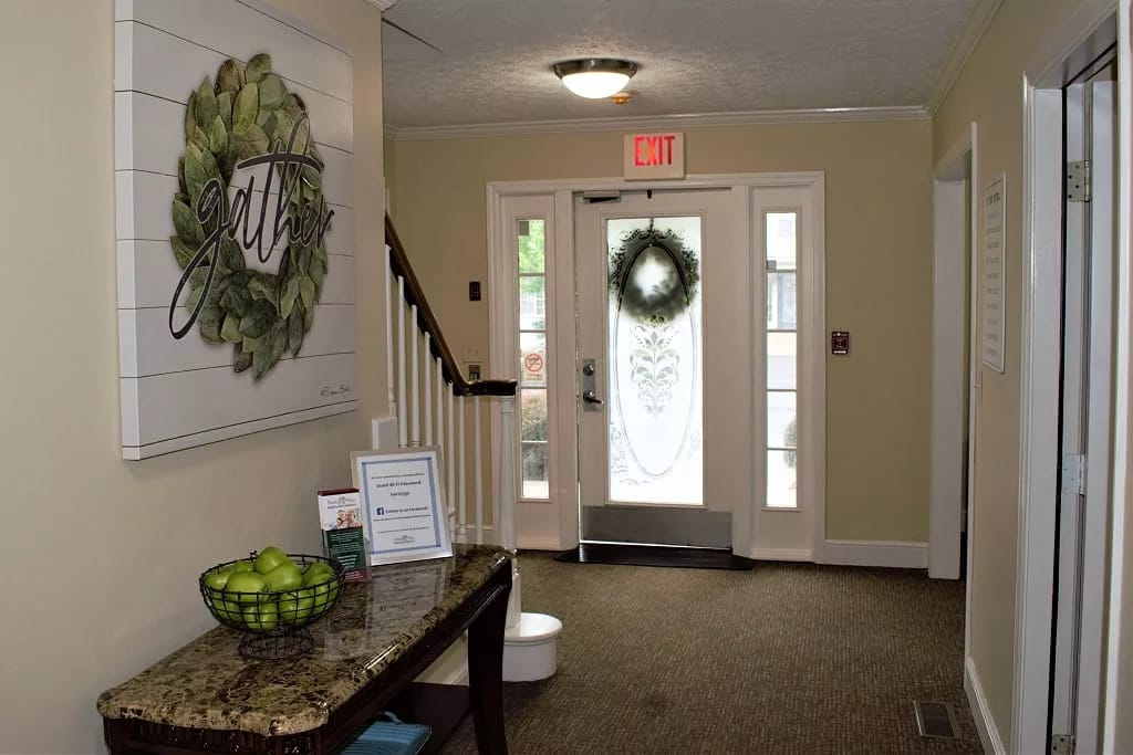 Hallway with a 'gather' sign and a decorative wreath