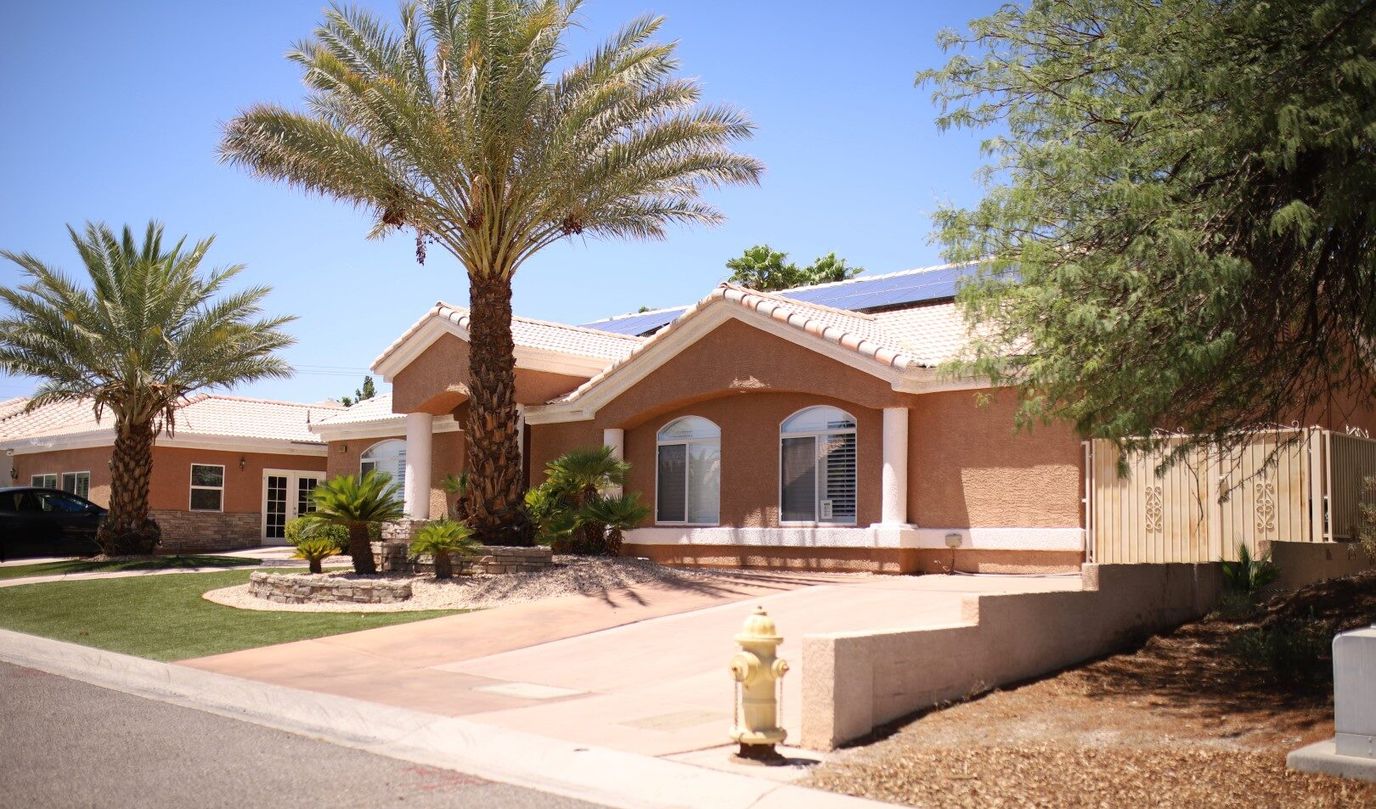 Exterior view of a senior living facility with palm trees