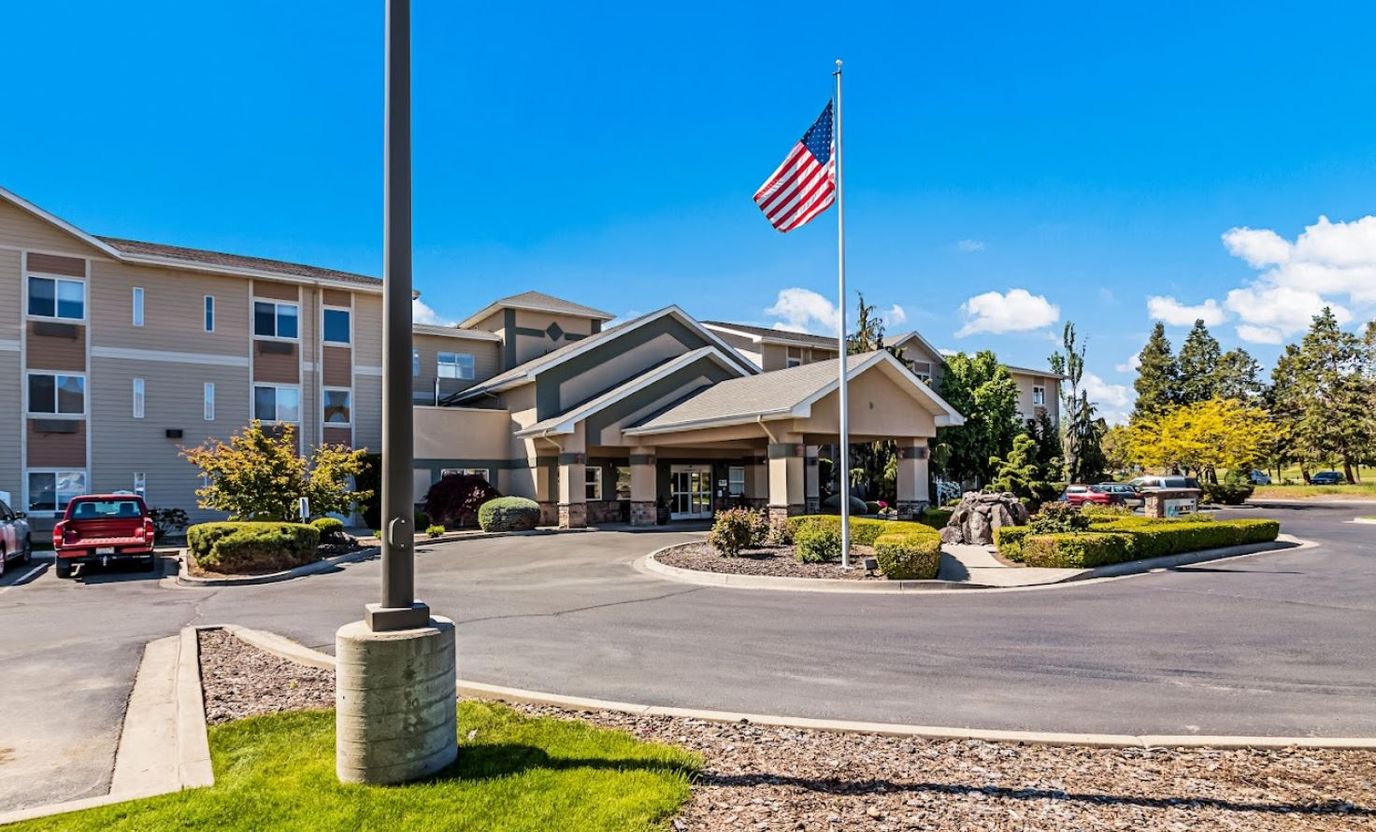 Exterior view of senior living facility with American flag