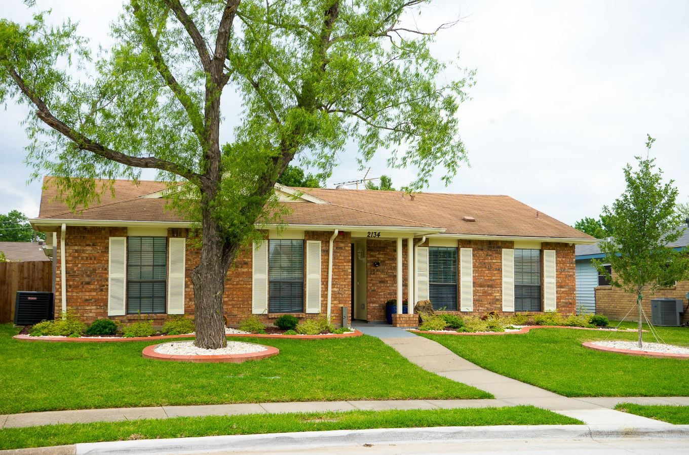 Exterior view of a brick house with a well-maintained garden