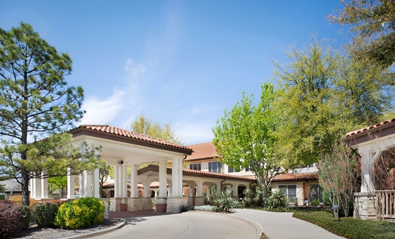 Exterior view of Sunrise of Frisco with trees and landscaping