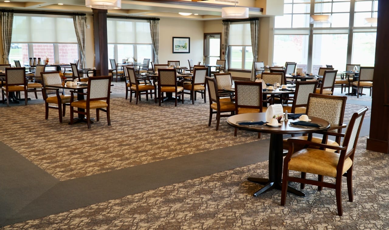 Spacious dining room with tables and chairs set for meals.