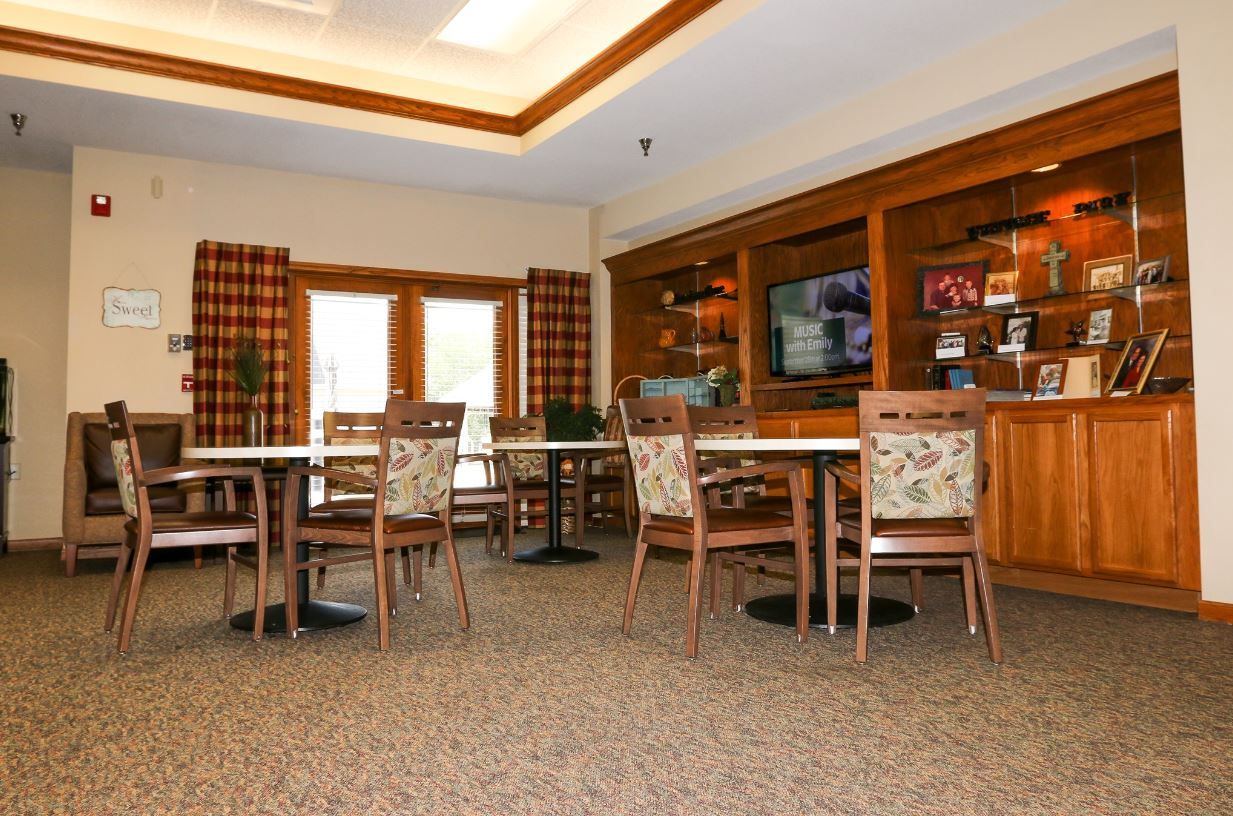Cozy common area with tables and chairs surrounded by natural light