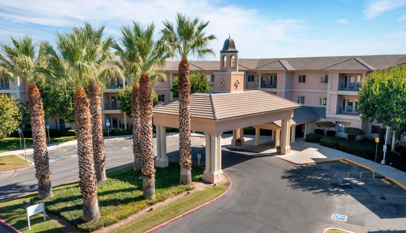 Front entrance of Hallmark Assisted Living with palm trees