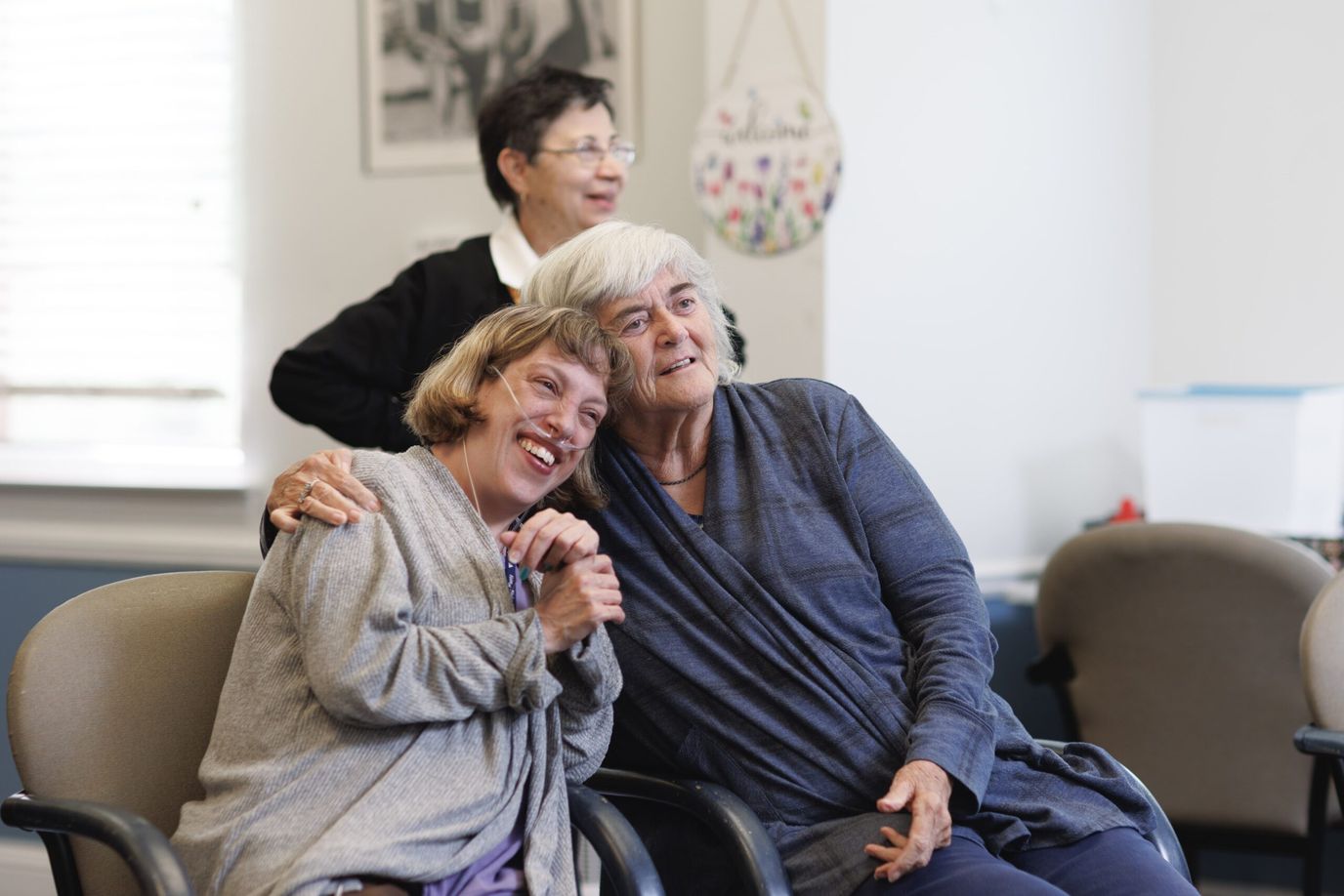 Two residents smiling and embracing in a communal area