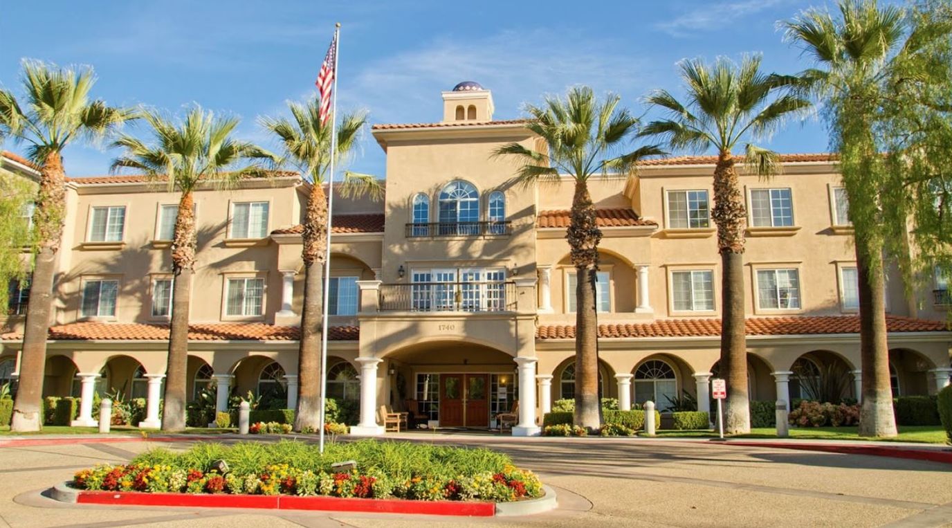 Exterior view of Bayshire San Dimas facility with palm trees