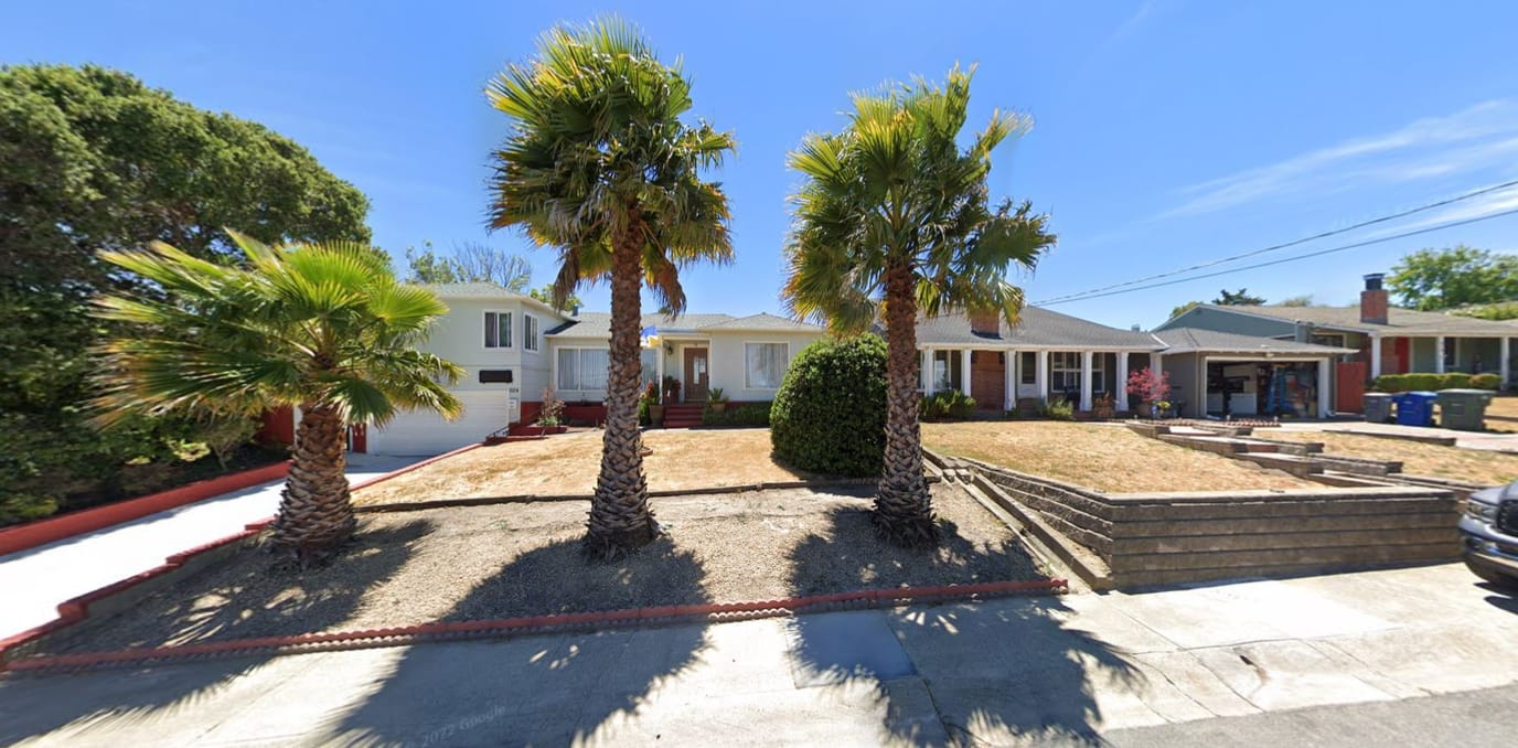 Exterior view of a senior care facility with palm trees