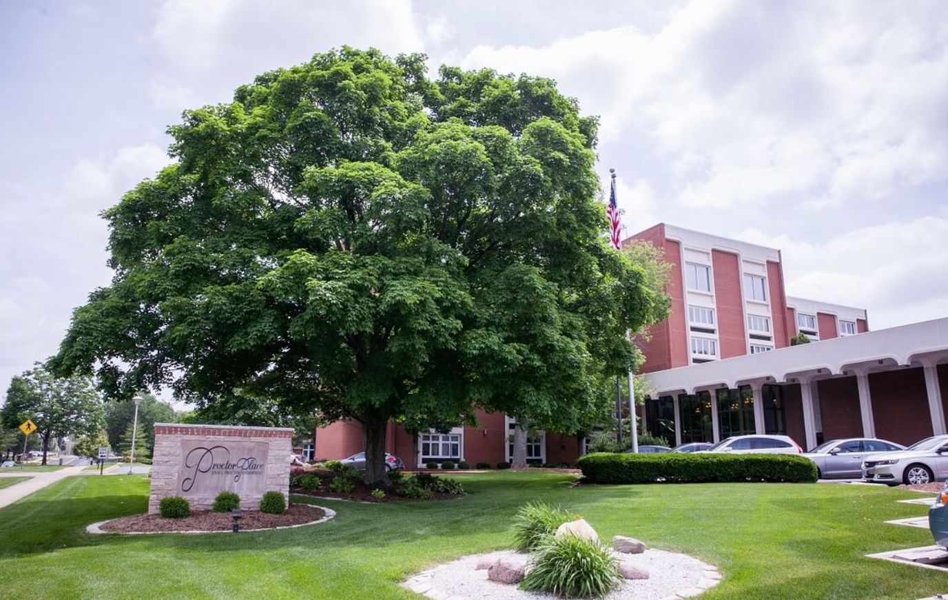 Exterior view of Proctor Place with a large tree and landscaping