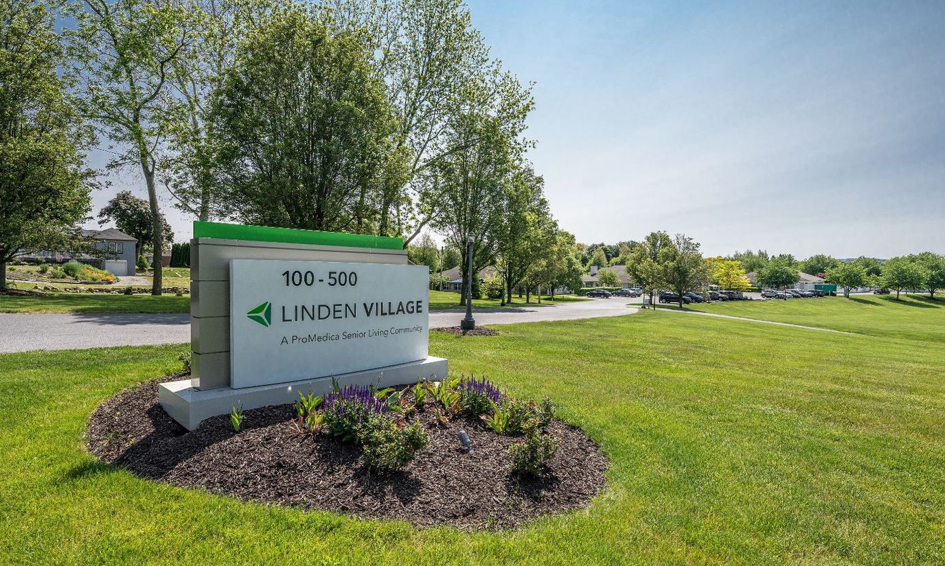 Sign for Linden Village in a green outdoor space