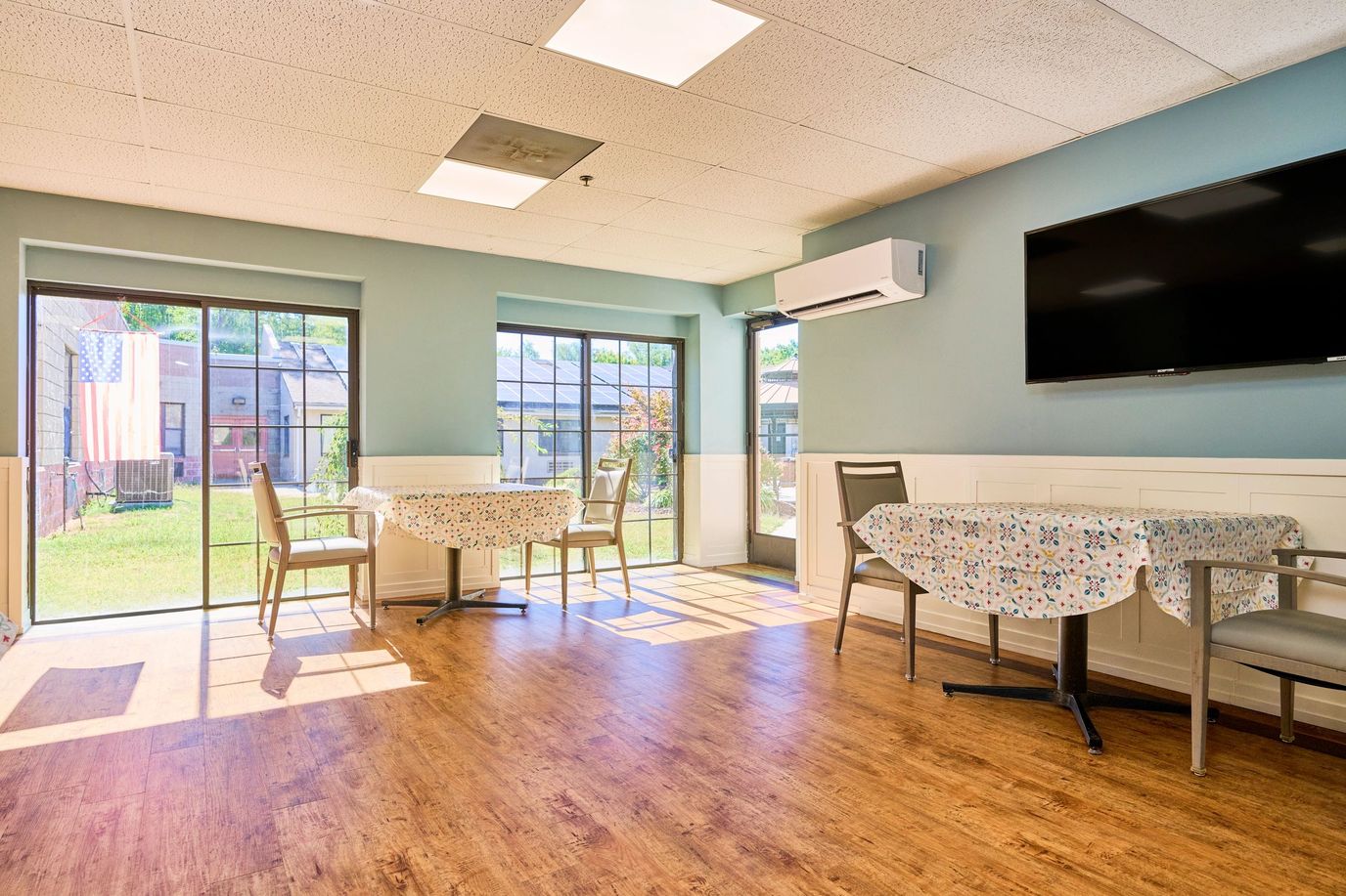 Bright and inviting common area with tables and outdoor views