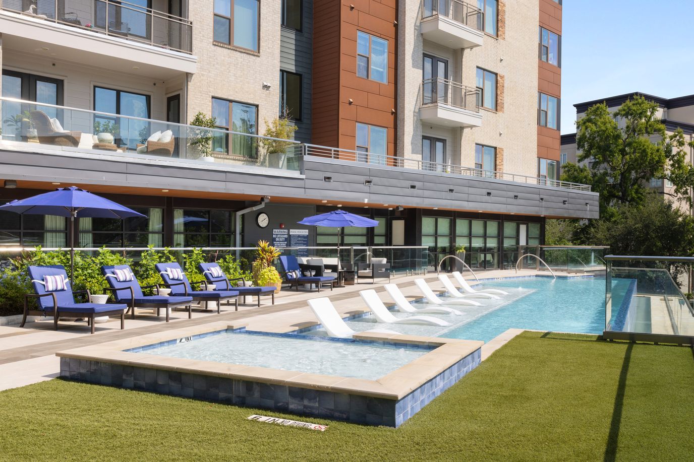 Outdoor pool area with lounge chairs and umbrellas