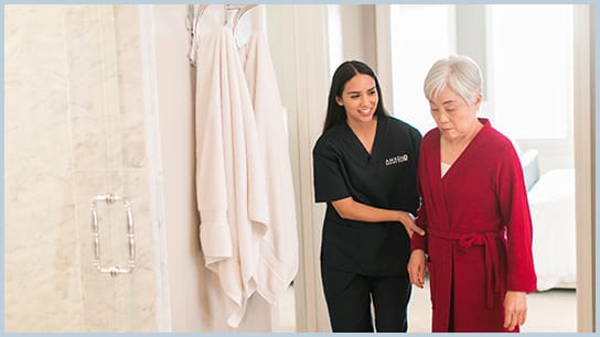 Caregiver assisting a senior resident indoors